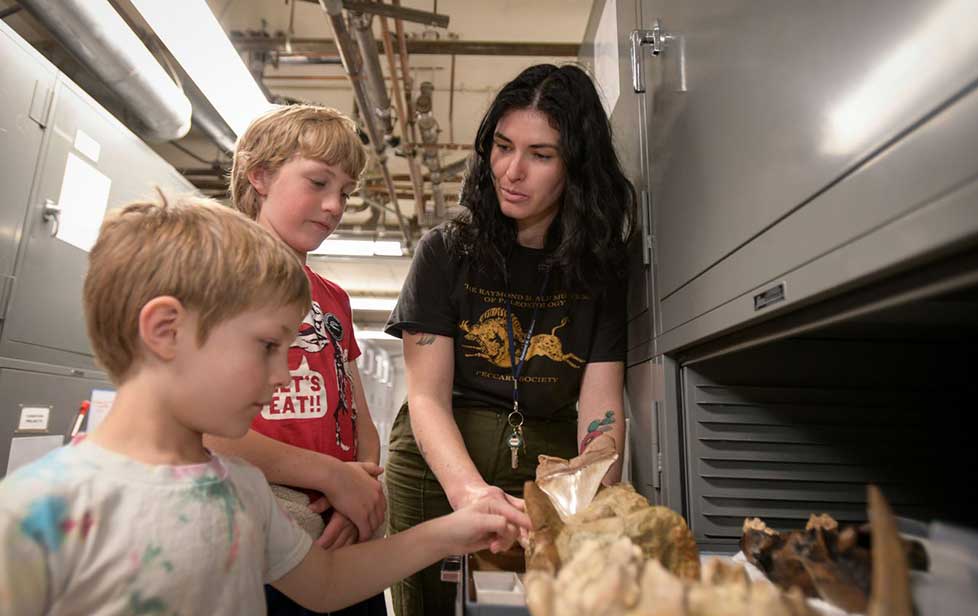 student showing fossils to kids at a Fossil Fest